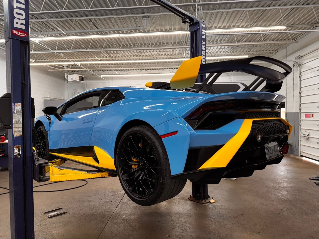 Blue Lamborghini Huracan on a lift at Redline Autohaus